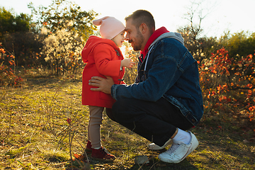 Image showing Happy father and little cute daughter walking down the forest path in autumn sunny day