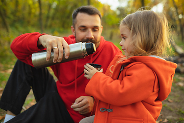 Image showing Happy father and little cute daughter walking down the forest path in autumn sunny day