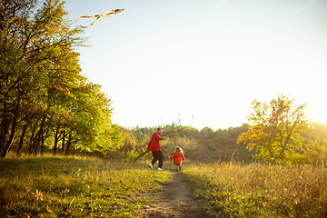 Image showing Happy father and little cute daughter walking down the forest path in autumn sunny day