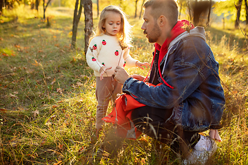 Image showing Happy father and little cute daughter walking down the forest path in autumn sunny day