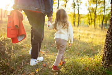 Image showing Happy father and little cute daughter walking down the forest path in autumn sunny day