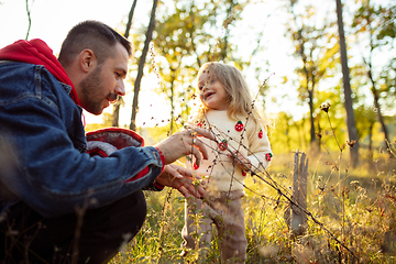 Image showing Happy father and little cute daughter walking down the forest path in autumn sunny day