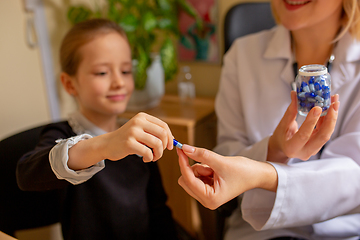 Image showing Paediatrician doctor examining a child in comfortabe medical office