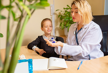 Image showing Paediatrician doctor examining a child in comfortabe medical office