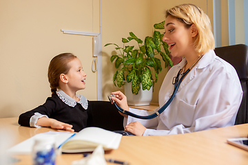 Image showing Paediatrician doctor examining a child in comfortabe medical office