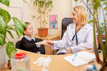 Image showing Paediatrician doctor examining a child in comfortabe medical office