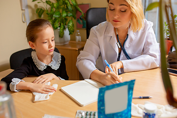 Image showing Paediatrician doctor examining a child in comfortabe medical office