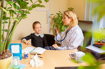 Image showing Paediatrician doctor examining a child in comfortabe medical office