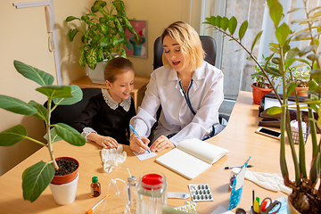 Image showing Paediatrician doctor examining a child in comfortabe medical office