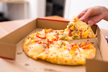 Image showing Woman taking on slice from pizza