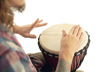 Image showing Man plays ethnic drum darbuka percussion, close up musician isolated on white studio background