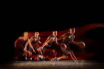Image showing Young east asian basketball player in action and jump in mixed strobe light over dark studio background. Concept of sport, movement, energy and dynamic, healthy lifestyle.