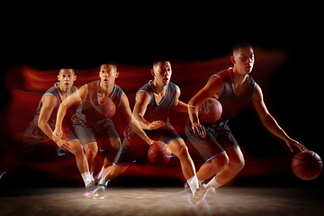 Image showing Young east asian basketball player in action and jump in mixed strobe light over dark studio background. Concept of sport, movement, energy and dynamic, healthy lifestyle.