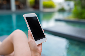Image showing Young Woman using cellphone and lying besides swimming pool