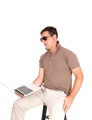 Image showing Middle age man sitting on a chair with laptop