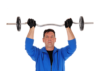 Image showing Tall man lifting the weight in blue jacket