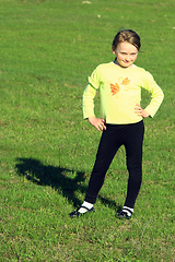 Image showing little girl standing on the green grass