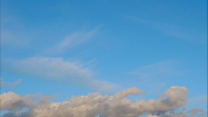 Image showing Time lapse Fluffy clouds float across the blue sky. UltraHD stock footage