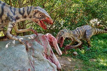 Image showing prehistoric dinosaurs raptors attacking its prey