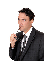 Image showing Businessman thinking with glasses in his mouths