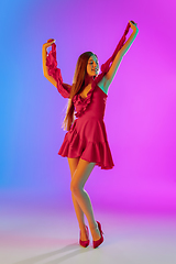 Image showing Beautiful happy girl in fashionable, romantic outfit on bright gradient purple-blue background in neon light