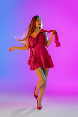 Image showing Beautiful happy girl in fashionable, romantic outfit on bright gradient purple-blue background in neon light