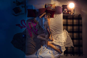 Image showing Top view of young professional rhythmic gymnast sleeping at her bedroom in sportwear with ribbon.