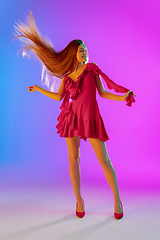 Image showing Beautiful happy girl in fashionable, romantic outfit on bright gradient purple-blue background in neon light