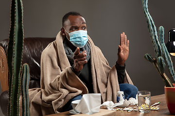 Image showing Man wrapped in a plaid wearing face mask trying to protect from somebody\'s sick