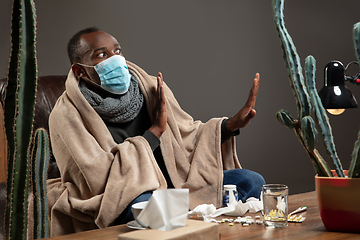 Image showing Man wrapped in a plaid wearing face mask trying to protect from somebody\'s sick
