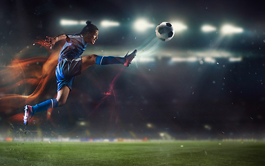 Image showing Young man football or soccer player kicking ball in jump at stadium - motion, action, activity concept. Flyer for ad, design.