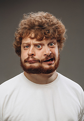 Image showing Young man with dual emotions combination on face isolated on dark background, emotional and expressive