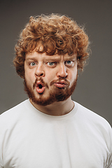 Image showing Young man with dual emotions combination on face isolated on dark background, emotional and expressive