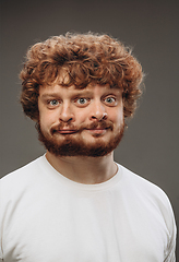 Image showing Young man with dual emotions combination on face isolated on dark background, emotional and expressive