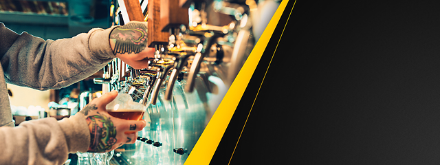 Image showing Hand of bartender pouring a large beer in tap. Horizontal banner, flyer for ad.