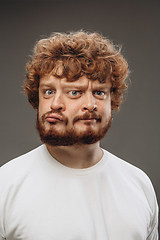 Image showing Young man with dual emotions combination on face isolated on dark background, emotional and expressive