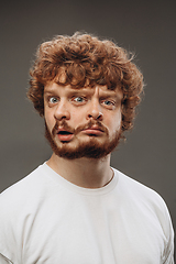 Image showing Young man with dual emotions combination on face isolated on dark background, emotional and expressive