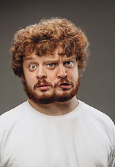 Image showing Young man with dual emotions combination on face isolated on dark background, emotional and expressive