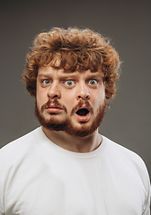 Image showing Young man with dual emotions combination on face isolated on dark background, emotional and expressive