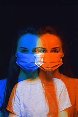 Image showing Close up portrait of caucasian woman wearing face mask on studio background. Modern and trendy duotone effect, double exposure