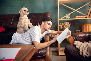 Image showing Young Caucasian man and his pet American Cocker Spaniel cream colour have a rest at home.