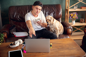 Image showing Two best friends young man and American Cocker Spaniel cream colour drink tea at home.