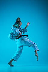 Image showing Young girl professional judoist isolated on blue studio background in neon light. Healthy lifestyle, sport concept.