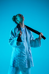 Image showing Young girl professional judoist isolated on blue studio background in neon light. Healthy lifestyle, sport concept.