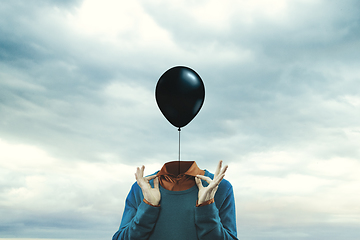 Image showing Contemporary art collage. Male body of model with black ballon instead head isolated on blue white background. Creativity, brain concept .