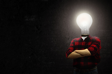 Image showing Contemporary collage. Male body with electric bulb instead head isolated on black background. Creativity, brain concept .