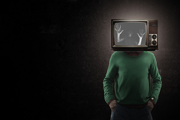 Image showing Contemporary art collage. Male body with TV set instead head isolated on black background. Creativity, brain concept .