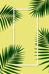 Image showing Exotic green tropical palm leaves isolated on yellow background with white geometric frame. Flyer for ad, design.