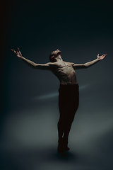 Image showing Young and graceful ballet dancer in minimal black style isolated on black studio background