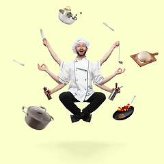 Image showing Handsome multi-armed cooker levitating isolated on yellow studio background with equipment